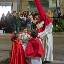 Kids with penitent wearing a red hood